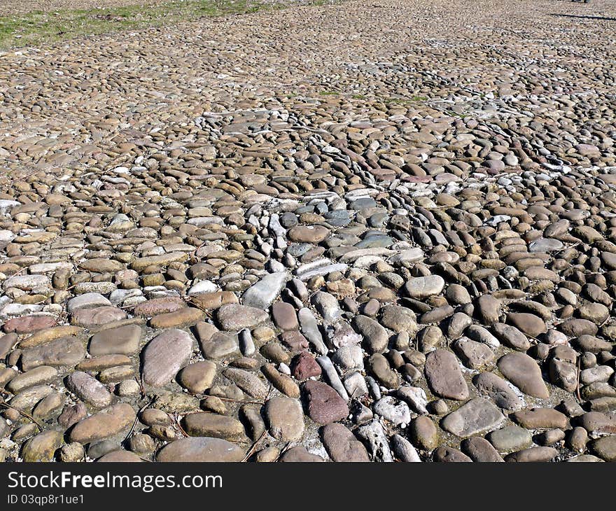 Texture of a pebble sidewalk in sunny day