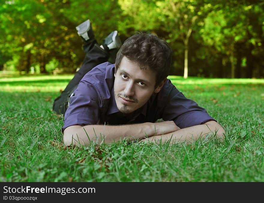 Handsome young man lying on a green meadow. Handsome young man lying on a green meadow