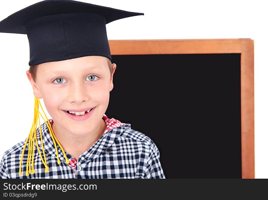 Graduate Boy In Cap With Blackboard In Background