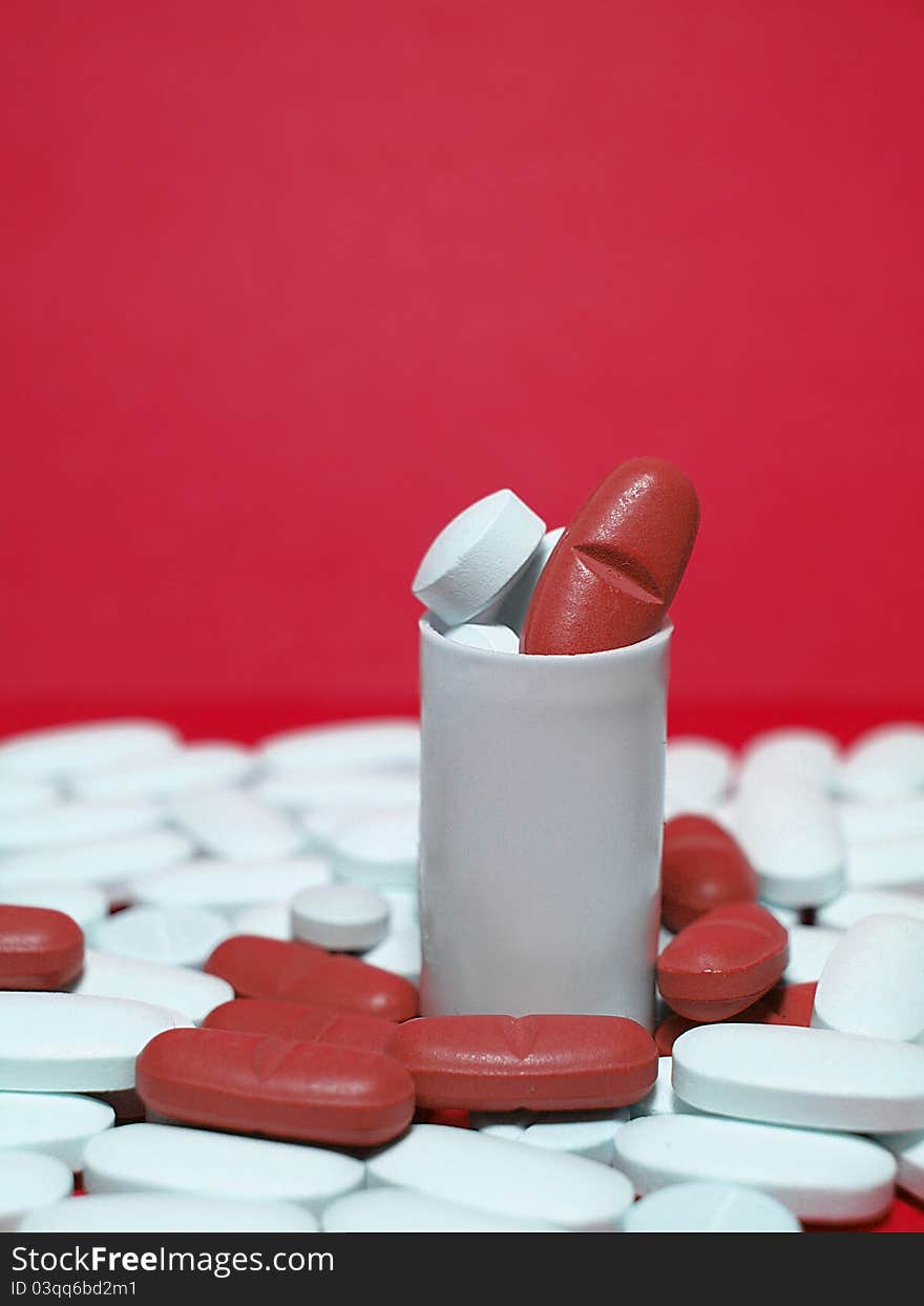 Red and white pills on red background