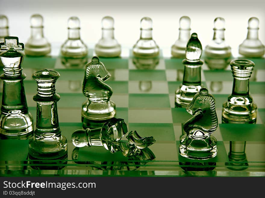 A glass chess board where one of the pieces is smashed. A glass chess board where one of the pieces is smashed