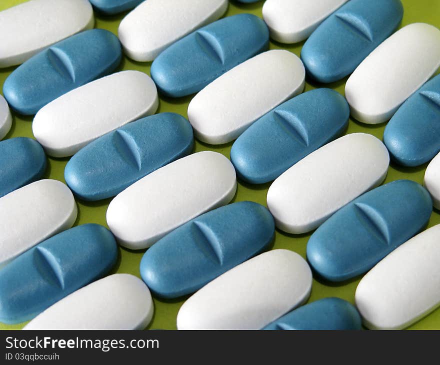 Many white and blue pills on blue background