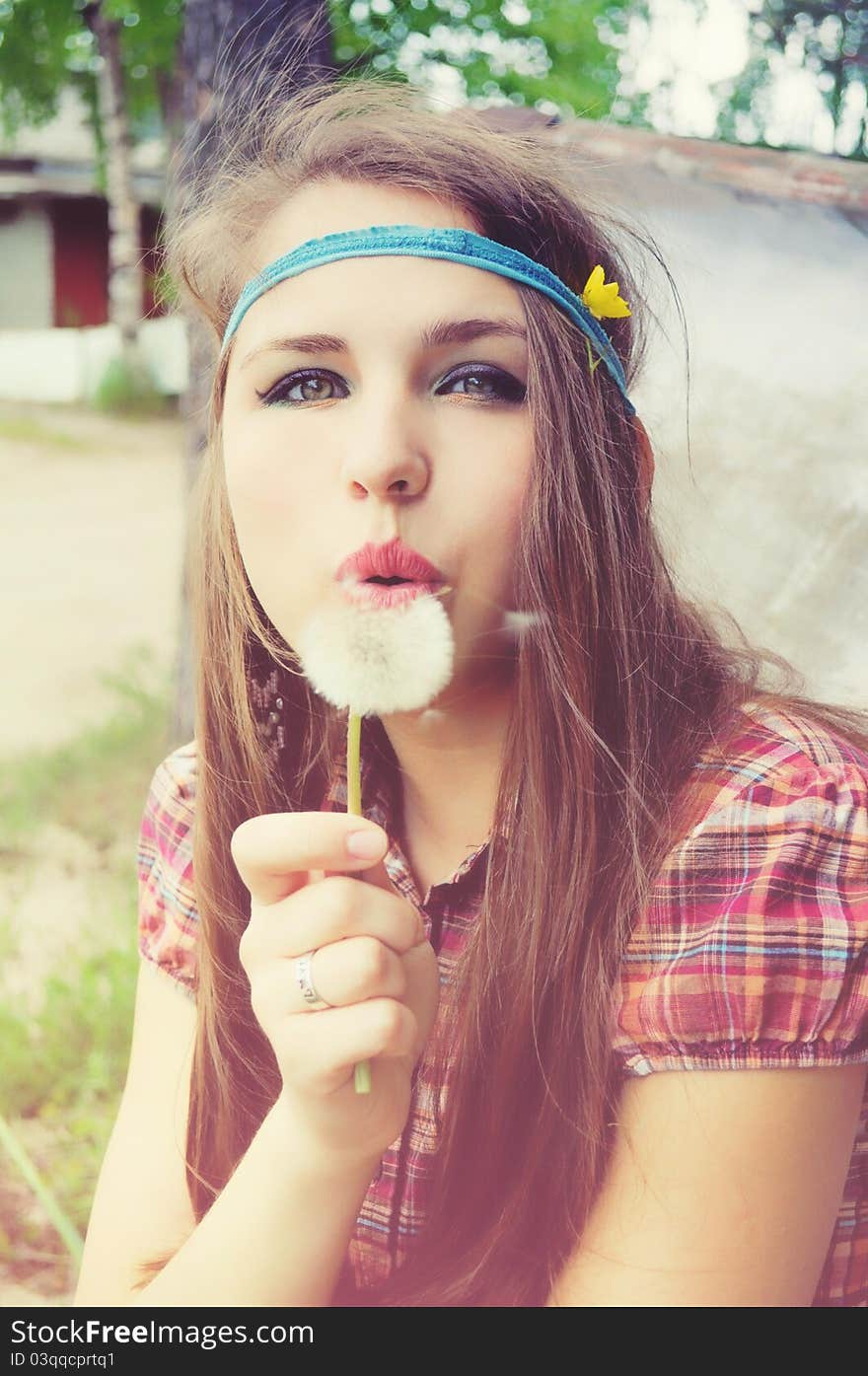 Girl Blowing A Dandelion