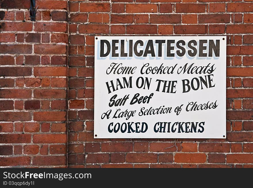 Old fashioned sign written shops sign on a red brick wall. Old fashioned sign written shops sign on a red brick wall