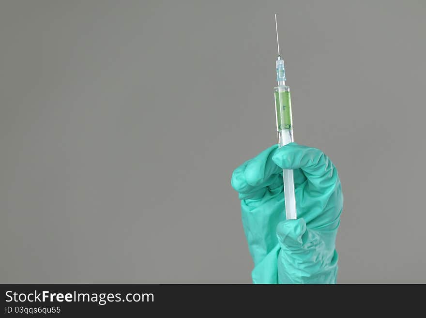 Syringe in hand on gray background