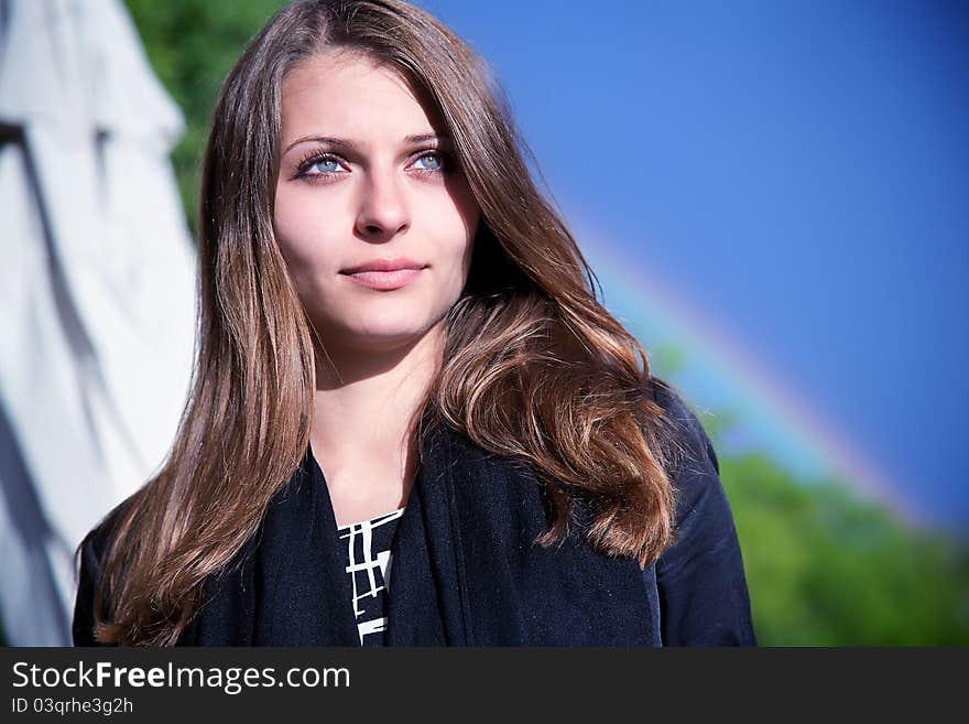 Portrait of a beautiful woman on the background of the rainbow