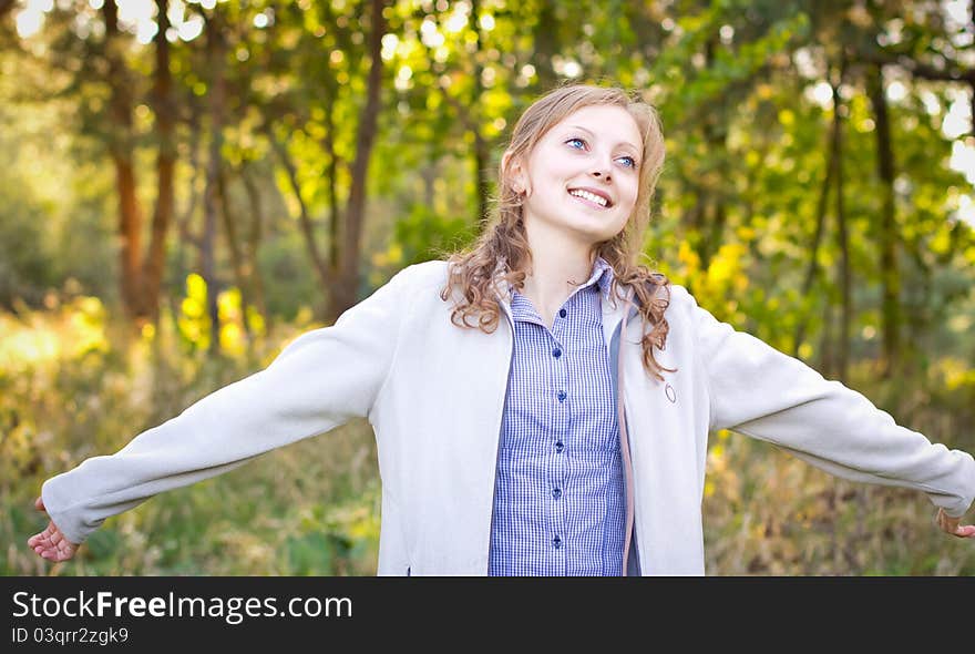 Young beautiful Girl with arms outstretched enjoying at the park. Young beautiful Girl with arms outstretched enjoying at the park