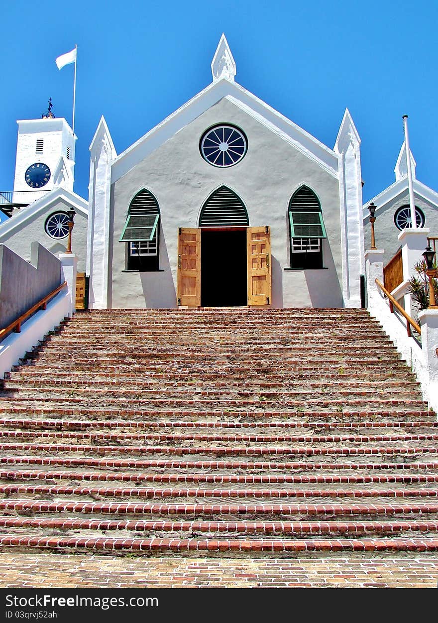 Stucco church with wooden door and brick steps