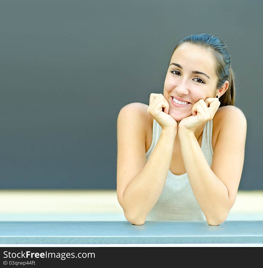 Smiling beautiful young woman resting head in hands. Smiling beautiful young woman resting head in hands