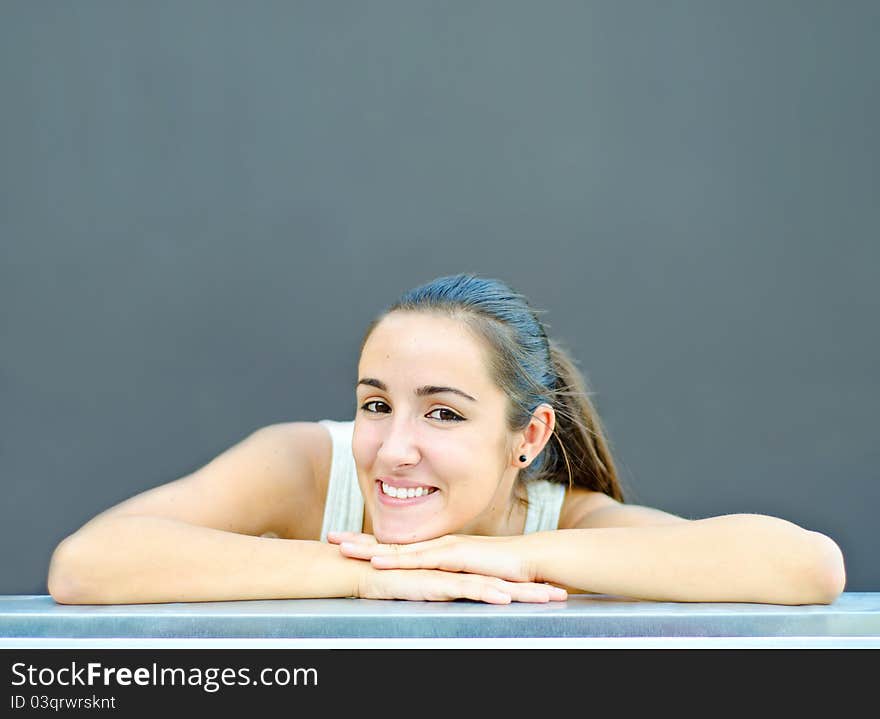 Smiling beautiful young woman resting head on hands. Smiling beautiful young woman resting head on hands