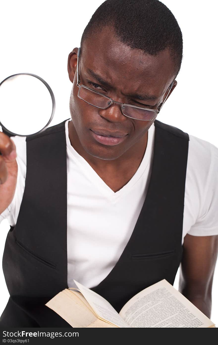 Young and beautiful black man holding a magnifying glass and reading a book