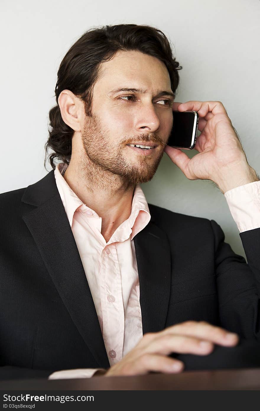 Young businessman sending an sms from his mobile phone. Young businessman sending an sms from his mobile phone