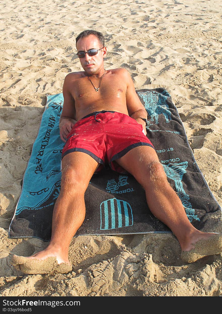 Boy lying on the towel sunbathing on the beach. Boy lying on the towel sunbathing on the beach