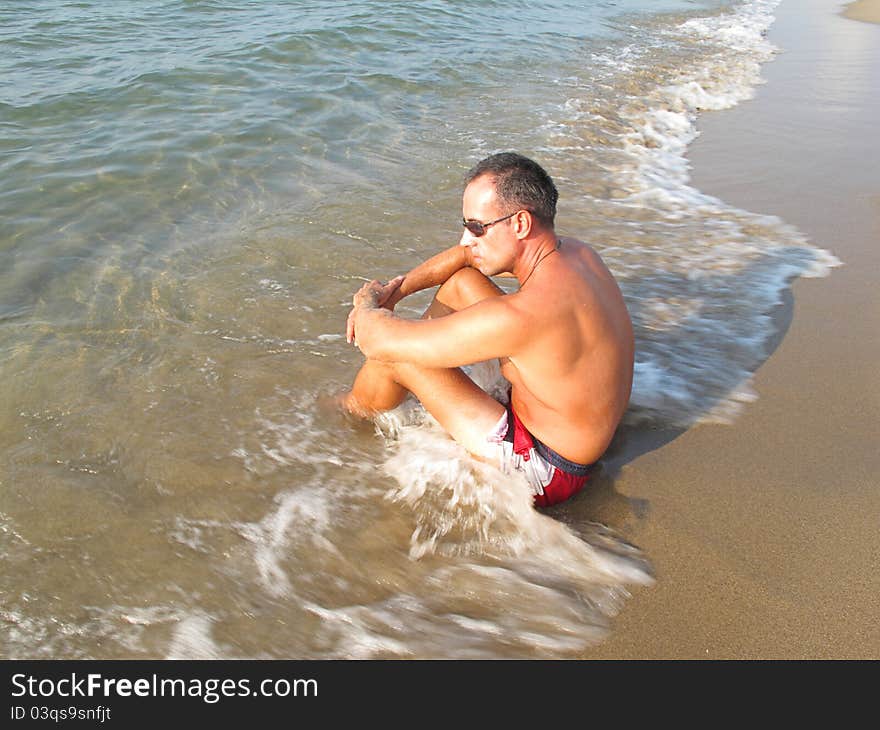 Boy sitting on the edge of the beach. Boy sitting on the edge of the beach