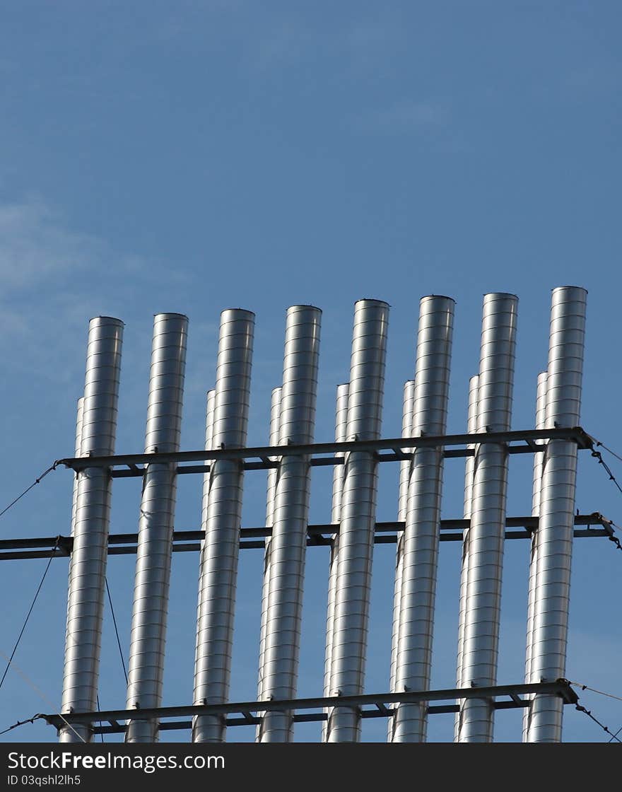 Vertical steel pipes with blue sky in background. Vertical steel pipes with blue sky in background