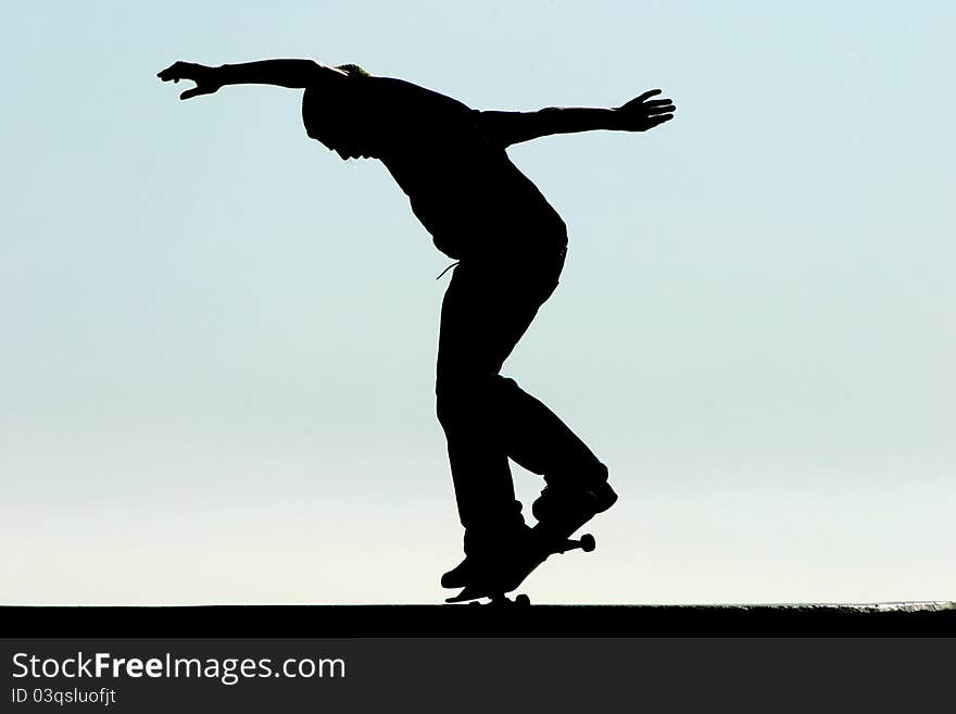 Male skateboarder jumps on a concrete edge at a skateboard park