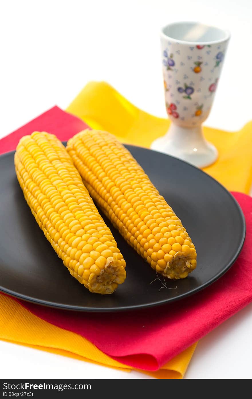 Cooked corn on black plate