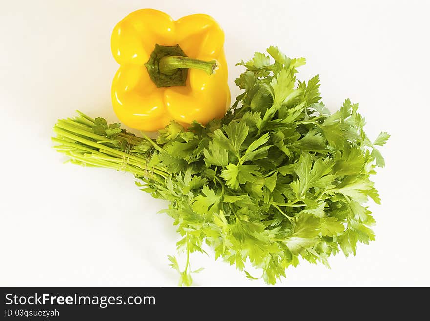 Yellow pepper and parsley on a white background