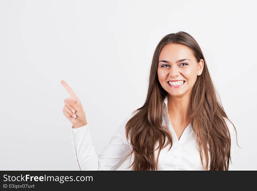 Happy smiling young business woman showing blank area for sign or copyspase, isolated on white background