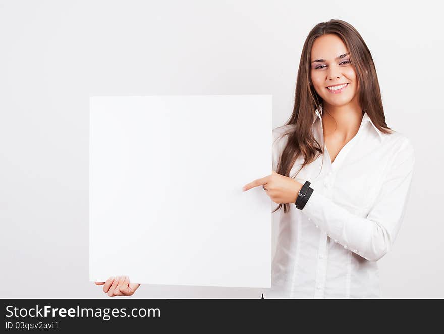 Happy smiling young business woman showing blank signboard, over white background