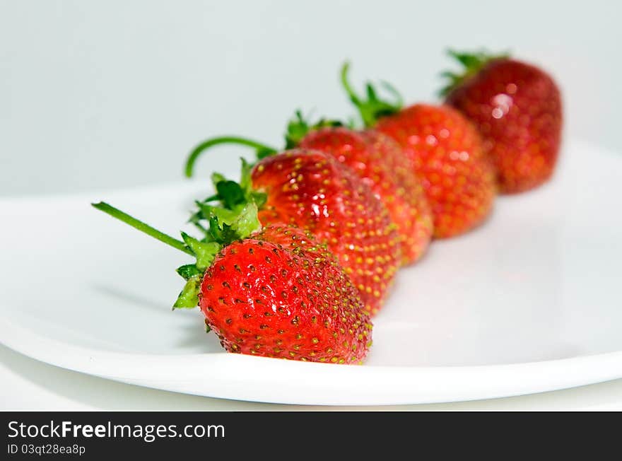 Combined in light the claim some mature berries of a strawberry ( focus on a forward strawberry)