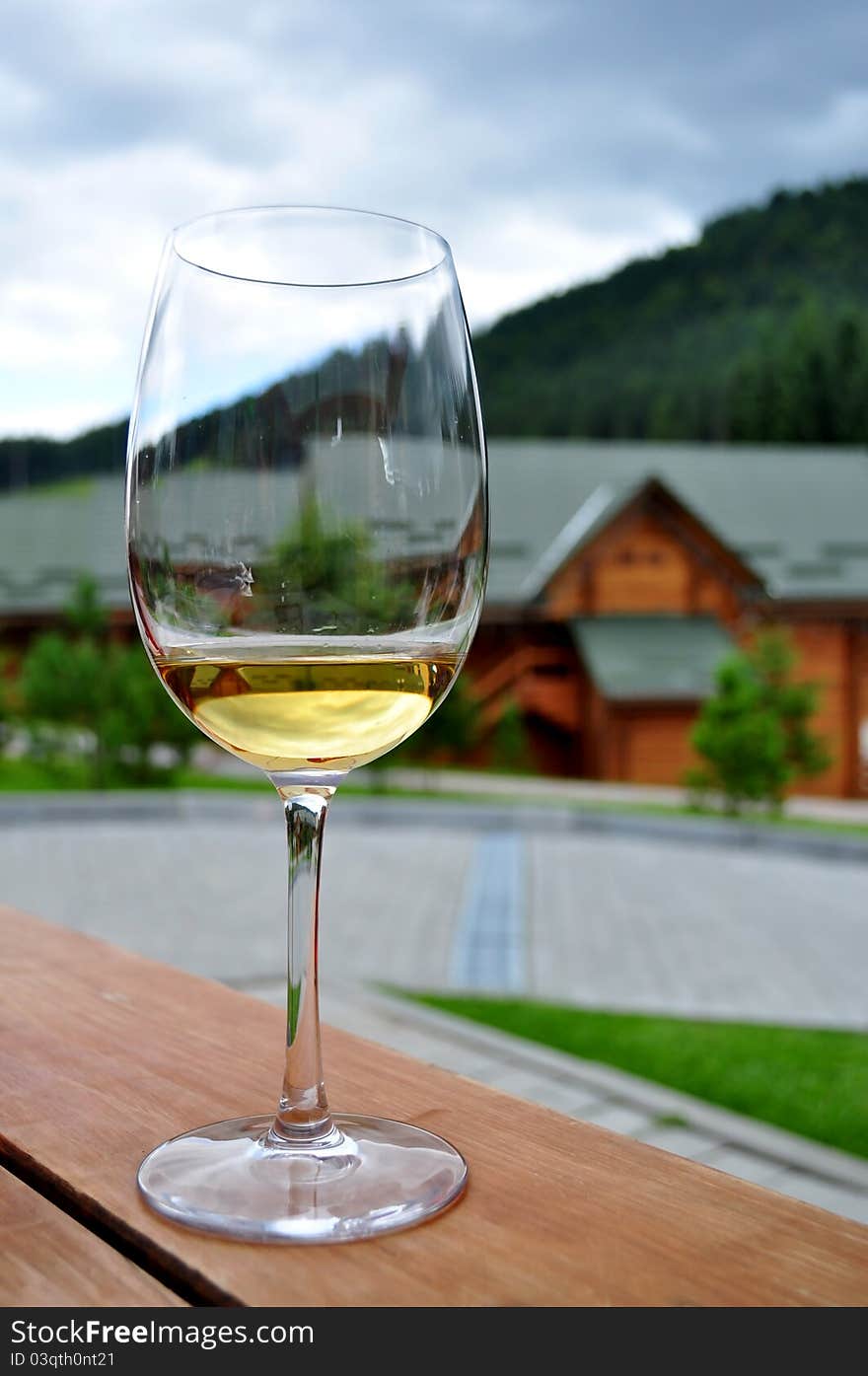 A glass of white wine on the background of villas