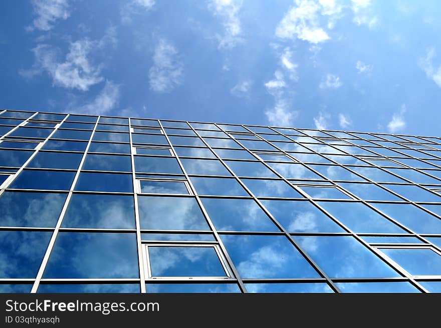 High-rise glass building with sky and clouds reflection. High-rise glass building with sky and clouds reflection