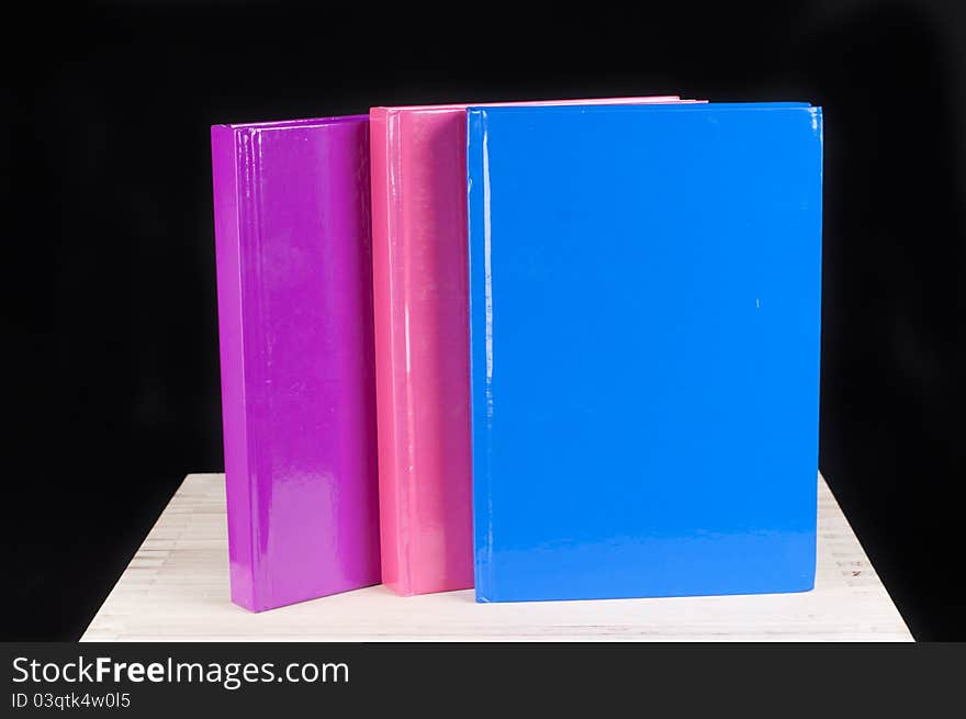 Pink, blue and magenta book on a black background