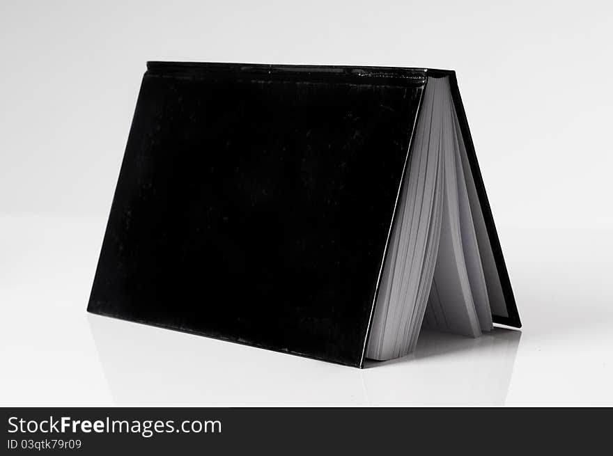 Black Book Open On A White Table