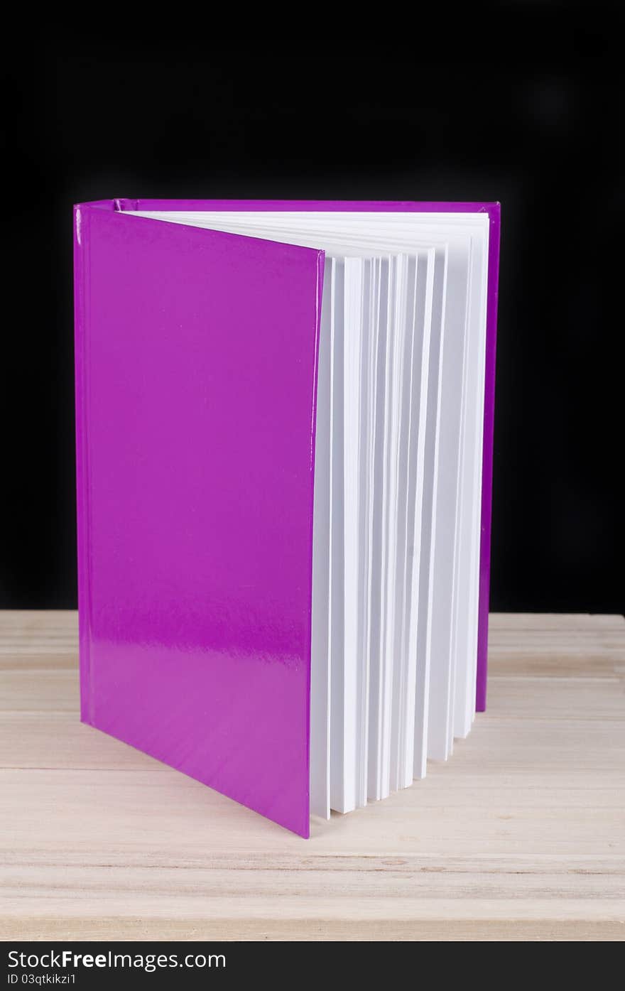 Pink book on a black studio background. Pink book on a black studio background