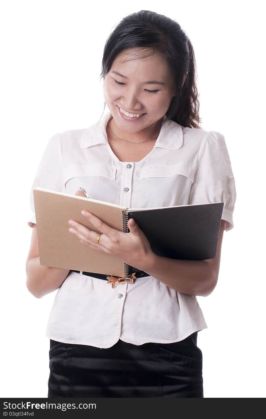 A Asian female secretary recording the notes with the sweet smiles on the white. A Asian female secretary recording the notes with the sweet smiles on the white