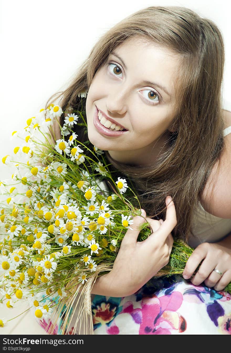 Happy young smiling girl with camomile against white background. Happy young smiling girl with camomile against white background