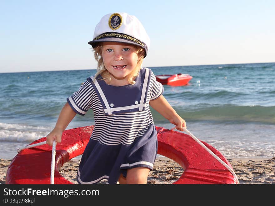 Happy girl in sailor hat on beach