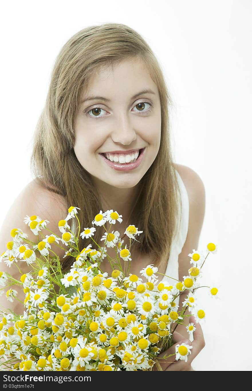 Happy young smiling brunette with daisy against light background. Happy young smiling brunette with daisy against light background