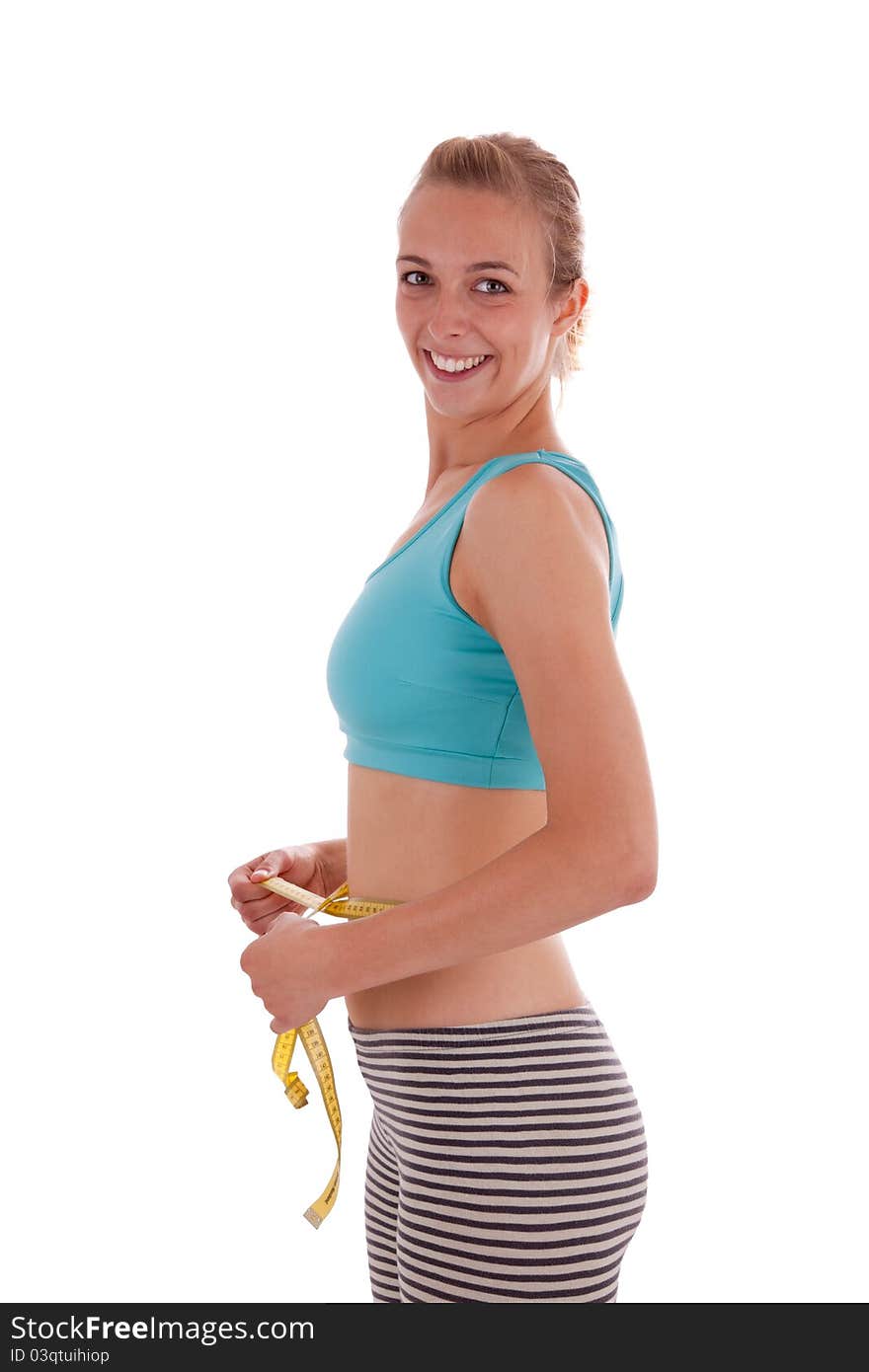 A young beautiful woman is measuring her abdominal girth. A young beautiful woman is measuring her abdominal girth