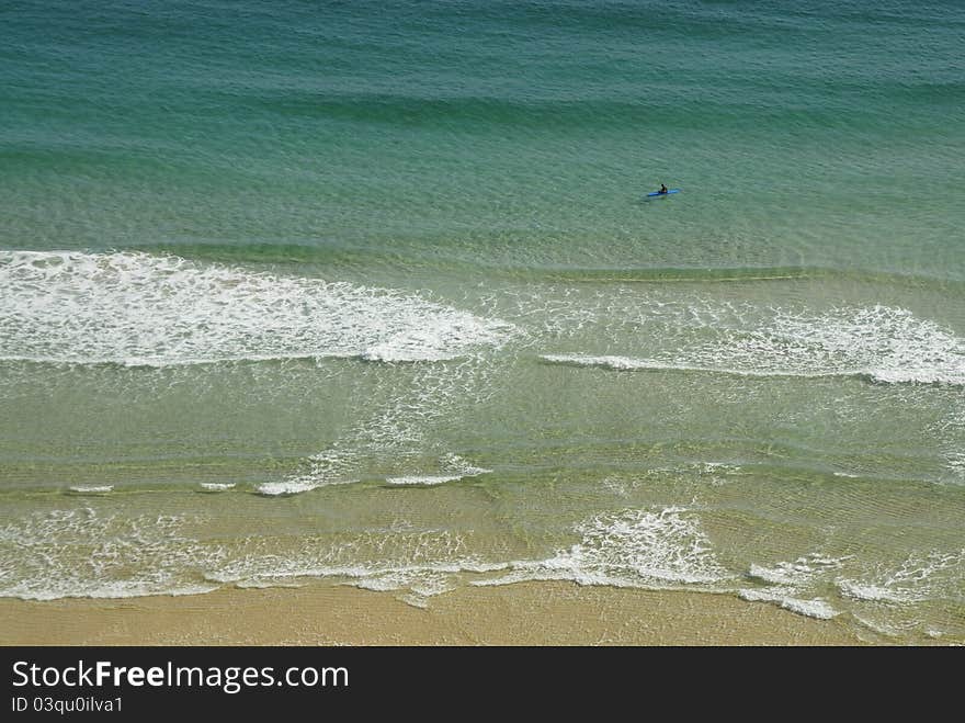 One lone man kyaking in the sea.