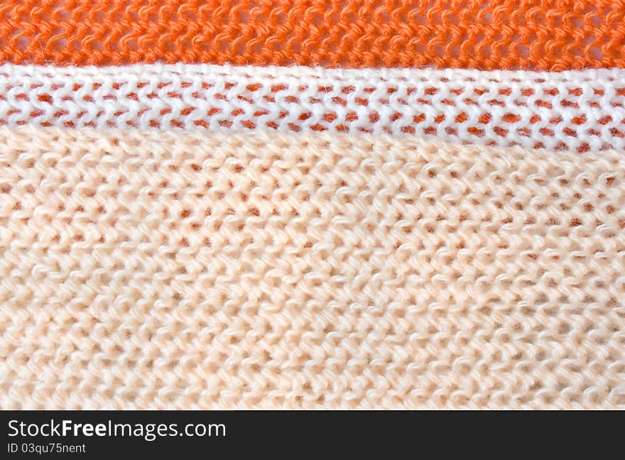 Three strip (orange, white, beige) of knitted fabric close up. Three strip (orange, white, beige) of knitted fabric close up.