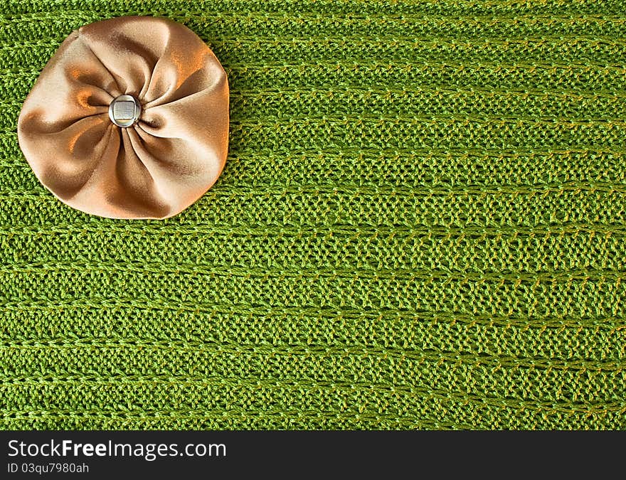 Brown with gold bow lies on the sparkling green knit fabric. Brown with gold bow lies on the sparkling green knit fabric.