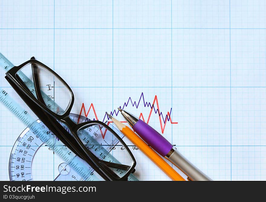 Closeup of spectacles and office tools on graph paper with diagram. Closeup of spectacles and office tools on graph paper with diagram