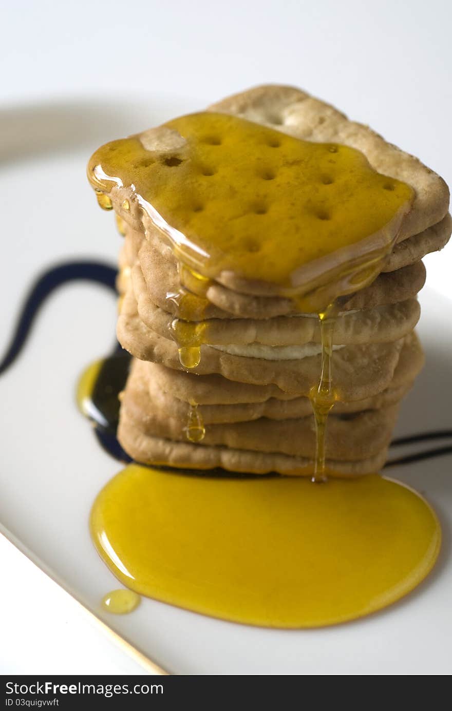 Honey and biscuit on a white plate for coffee brake.