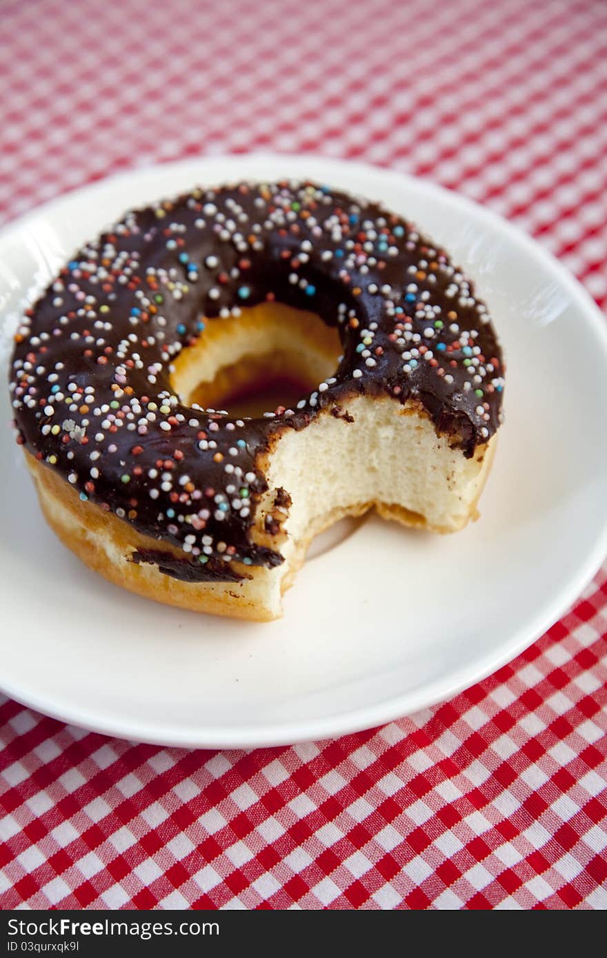 Cut donut at table on plate. Cut donut at table on plate.