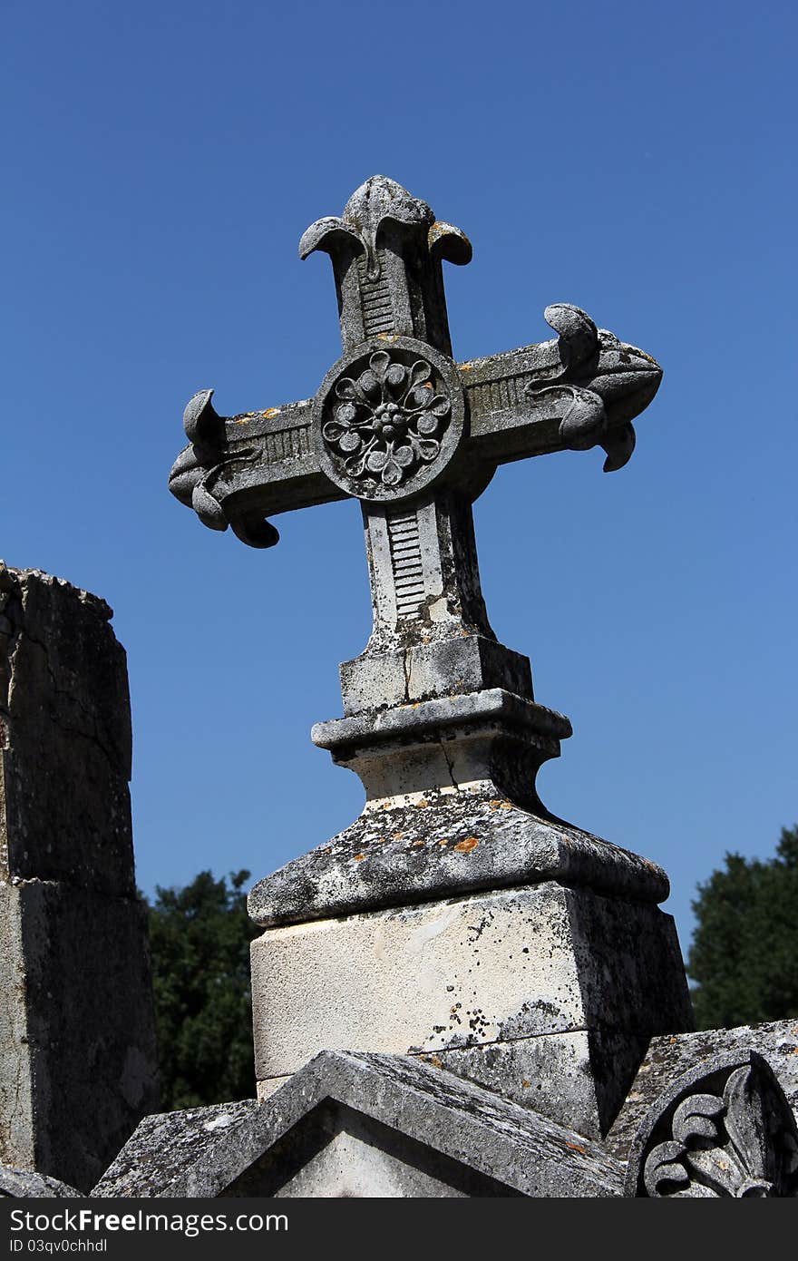 Old massive cross of a tombstone on a graveyard. Old massive cross of a tombstone on a graveyard