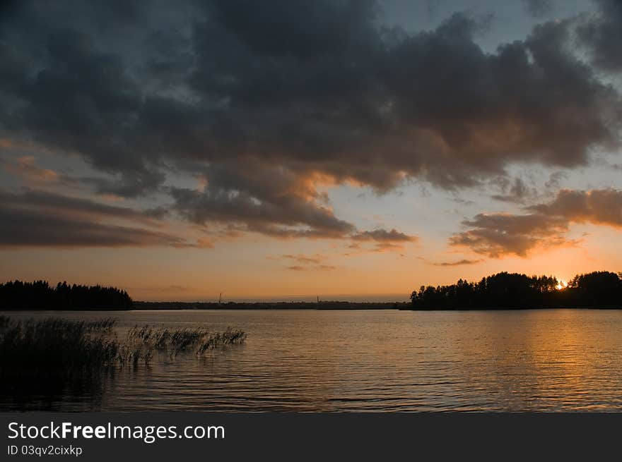 Night sky lit up the setting sun over the lake. Night sky lit up the setting sun over the lake