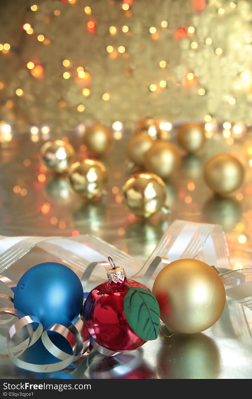 Baubles and ribbon on golden background with twinkle lights. Baubles and ribbon on golden background with twinkle lights.