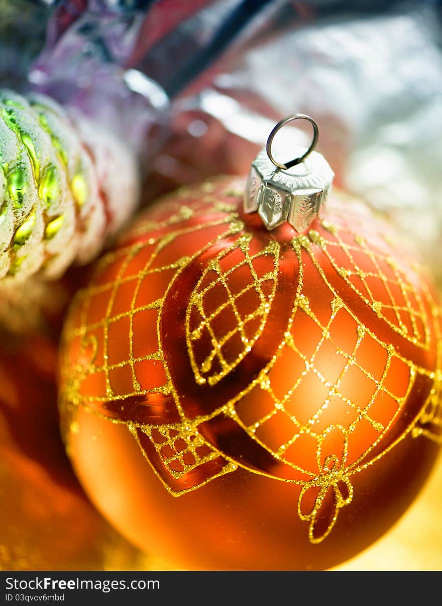 Christmas-tree decorations. One red ball is in focus.