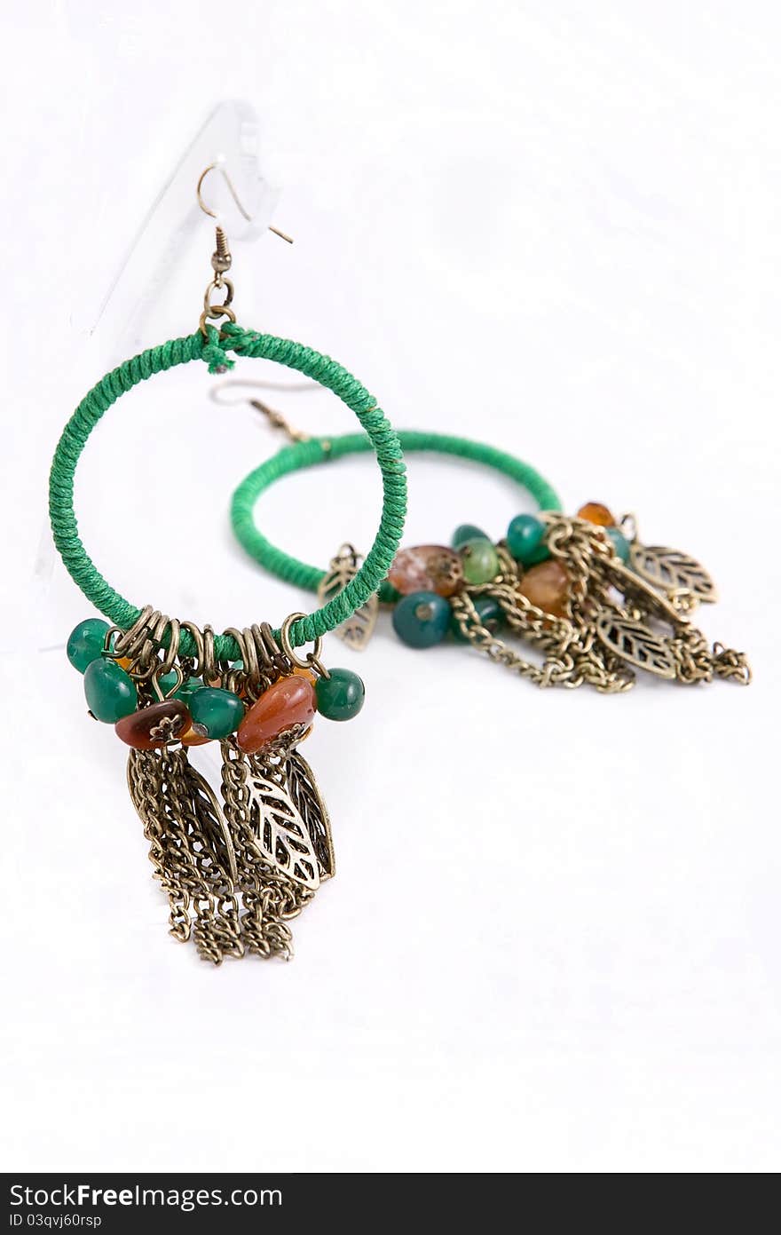 A pair of green earrings hanging on a web. A pair of green earrings hanging on a web