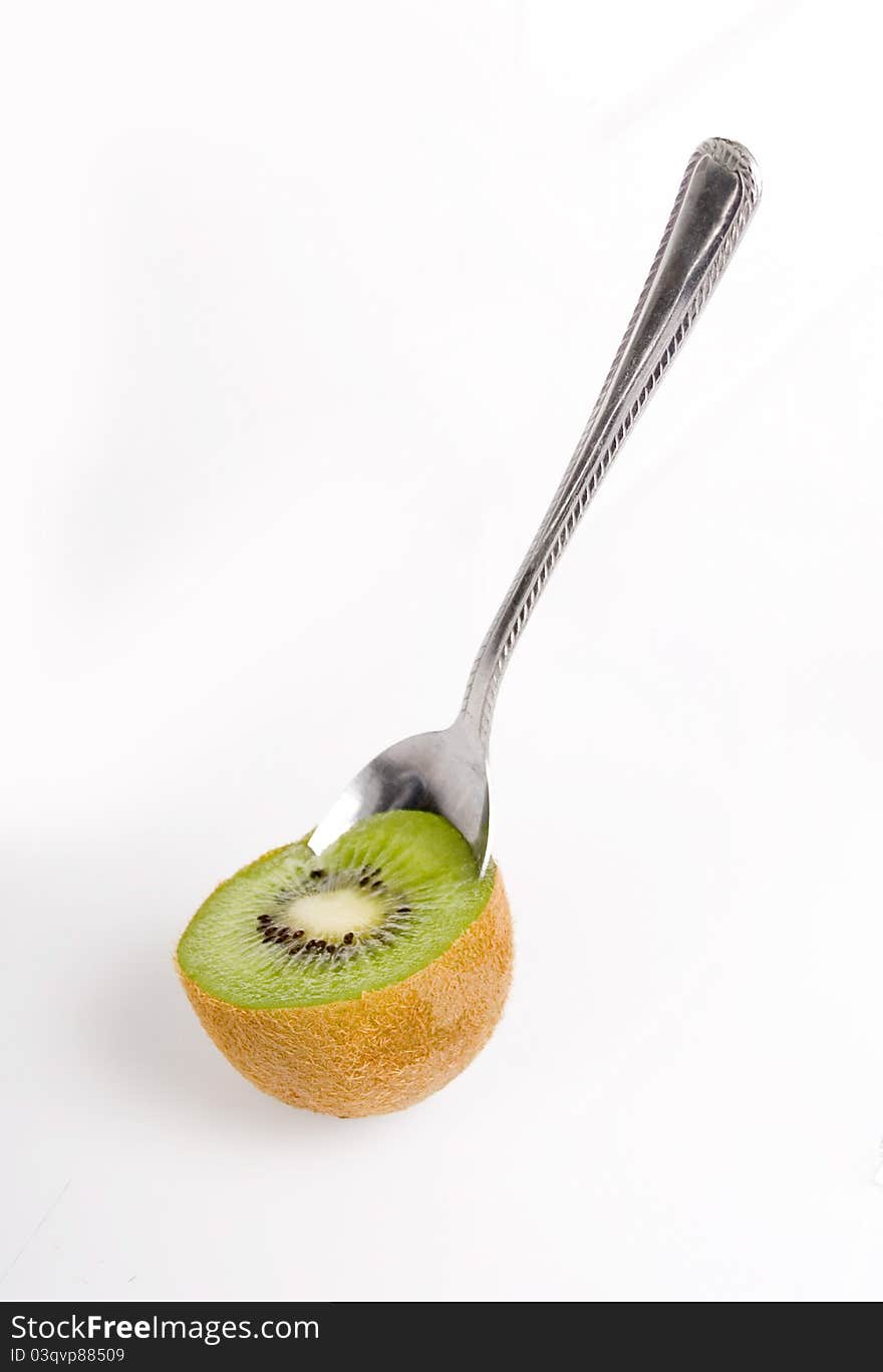 Spoon scooping kiwi on white background. Spoon scooping kiwi on white background