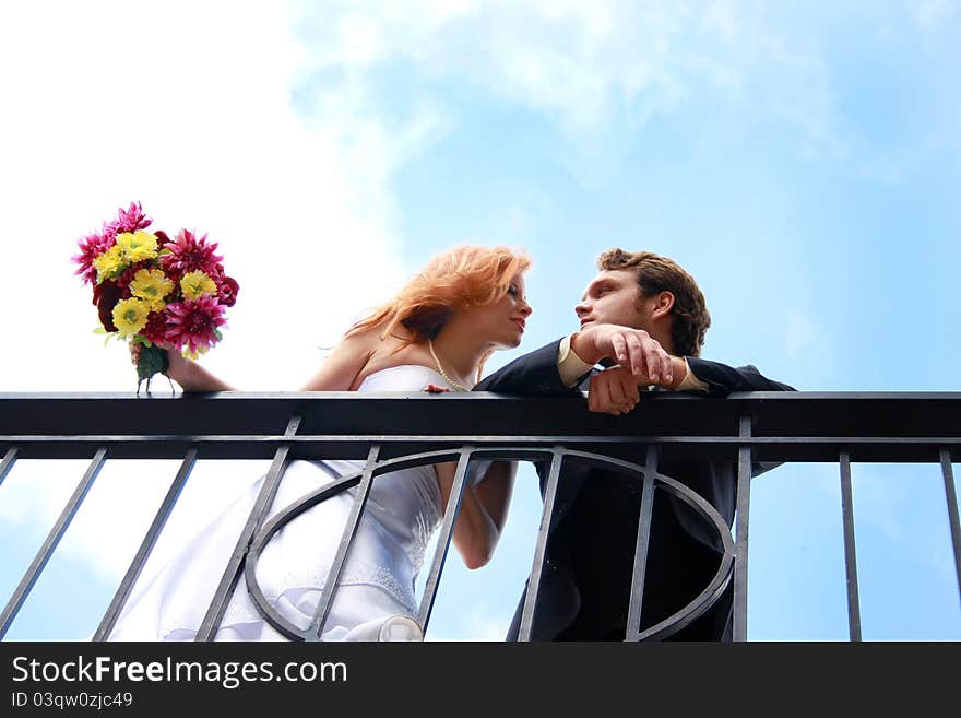 A bride and groom on a balcony. A bride and groom on a balcony