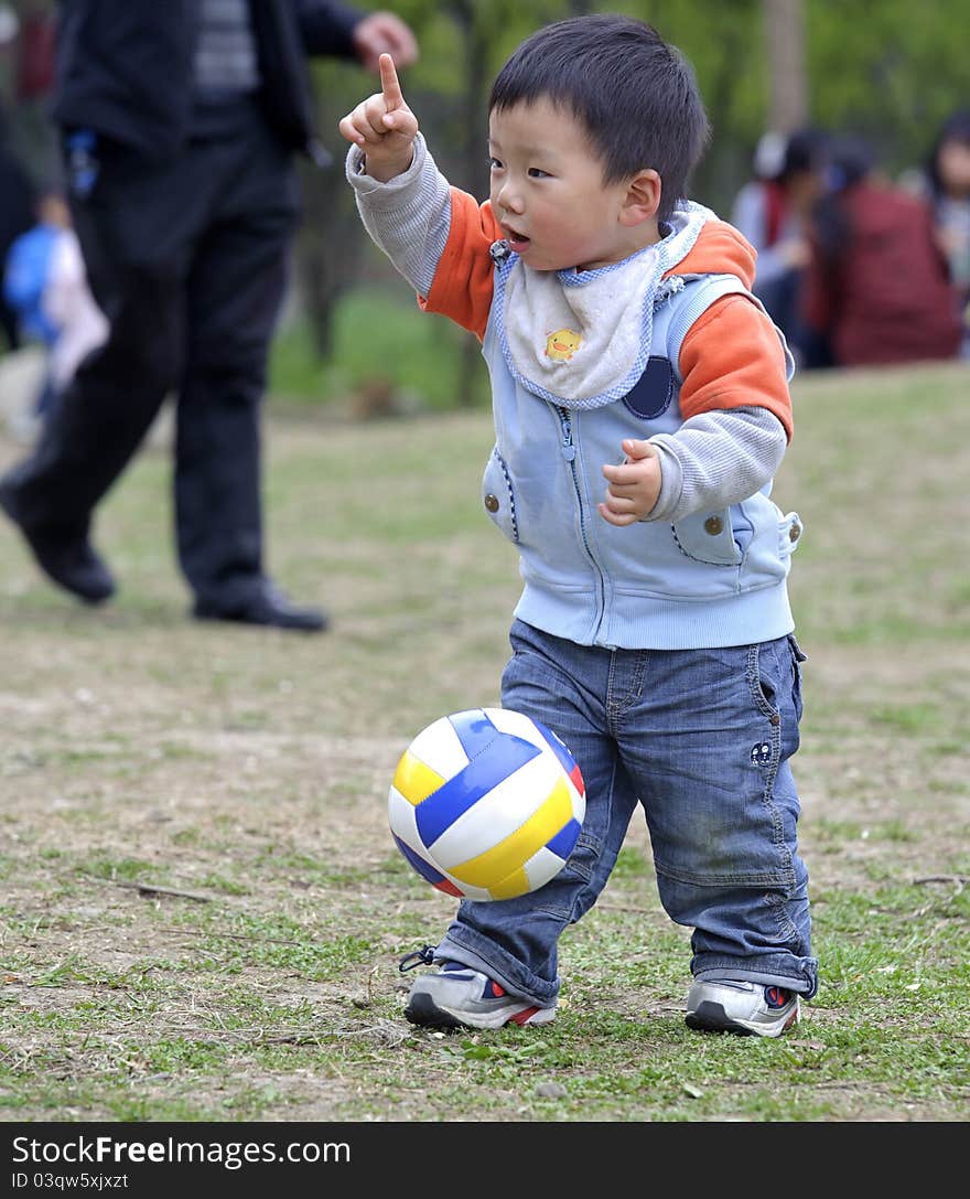 A cute baby is playing football. A cute baby is playing football