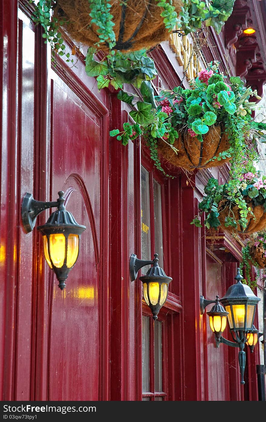 Vintage red facade with decorative lights and suspended flowers. Vintage red facade with decorative lights and suspended flowers